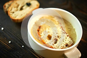 Broth with toasts of bread and black olives