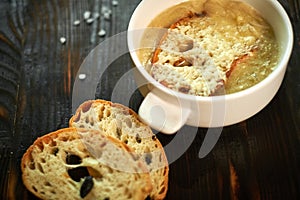 Broth with toasts of bread and black olives