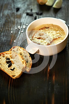 Broth with toasts of bread and black olives