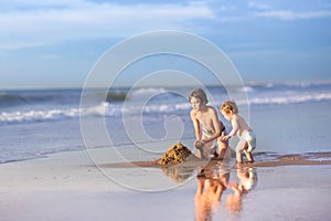 Brother and baby sister building a sand castle