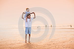 Brother and baby sister playing on beautiful beach at sunset