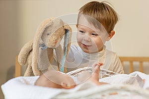 brother boy plays with newborn baby sister, Brother shows a newborn a toy. Toddler kid meeting new born sibling