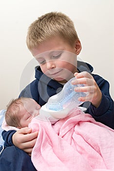 Brother feeding his sister.