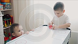 Brother plays air hockey and little sister watches him HD 1920x1080