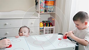 Brother plays air hockey and little sister watches him HD 1920x1080