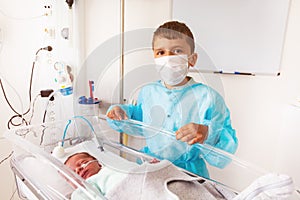 Brother and premature born infant child crib