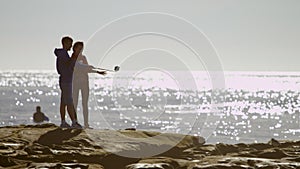 Brother and sisiter are taking a selfie on a coast