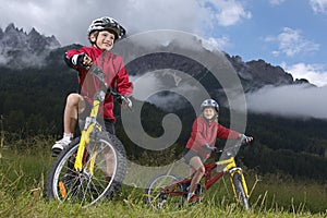 Brother and sister (7-9) on bikes in countryside