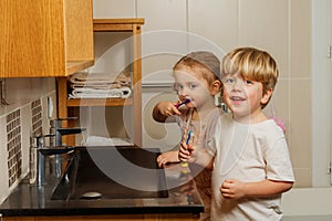 Brother and sister in the bathroom brushing teeth together