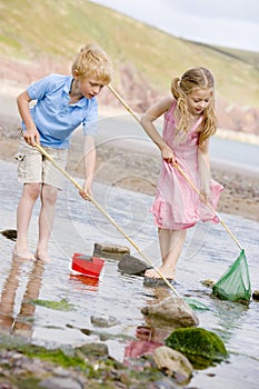 Brother and sister at beach with nets and pail