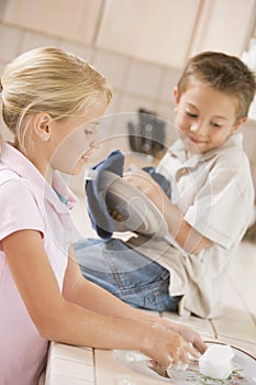 Brother And Sister Cleaning Dishes Together