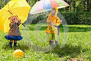 Brother and sister with colorful umbrellas in