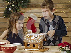 Brother and sister decorating gingerbread house