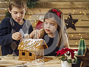 Brother and sister decorating gingerbread house