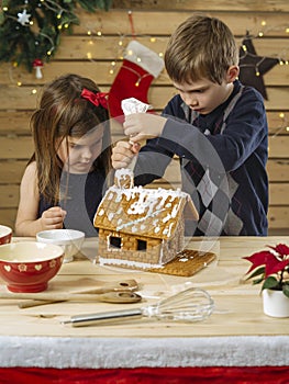 Brother and sister decorating gingerbread house