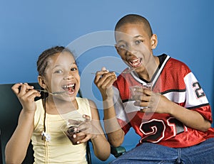 Brother and sister eating pudding