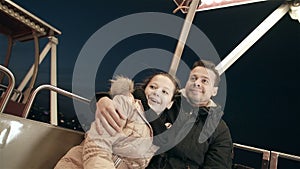 Brother and sister on the Ferris wheel. Lunapark in the evening with family.