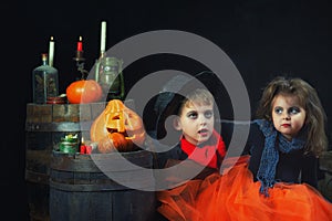 Brother and sister in Halloween costumes in the Studio on a dark background .