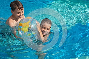 Brother sister having fun playing in pool