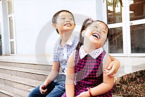 Brother and sister having fun and smiling outdoor together. Happy asian family with their children