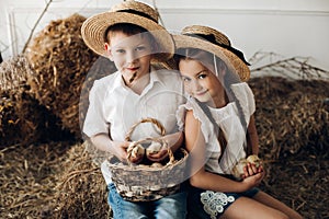 Brother and sister in hay hats keeping little chicks