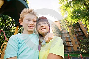 Brother and sister are hugging each other in a sunny day in the park