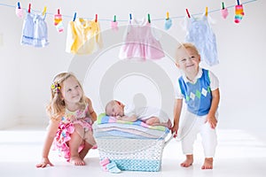 Brother and sister kissing newborn baby