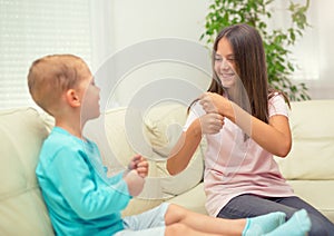 Brother and sister learn sign language at home.