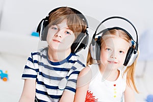 Brother and sister listening music with headphones