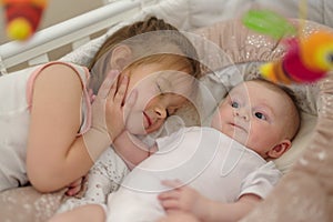 Brother and sister lying together in crib