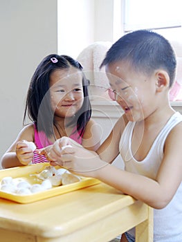 Brother and sister making dumplings