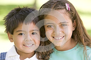 Brother and sister outdoors smiling