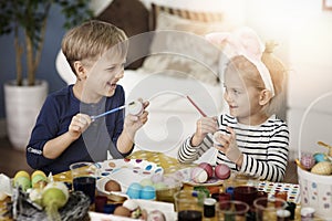 Brother and sister painting Easter eggs