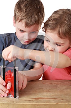 Brother and sister play with little guillotine