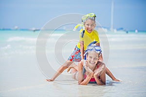 Brother and sister playing on the beach during the hot summer vacation day.