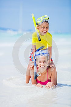 Brother and sister playing on the beach during the hot summer vacation day.