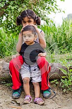 brother sister playing sitting at countryside