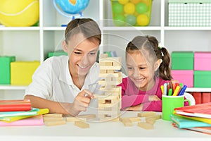 Brother and sister playing with wooden blocks at playroom