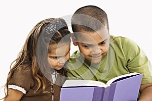 Brother and sister reading book.