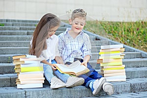Brother and sister are reading a book. The concept is back to school, education, reading, friendship