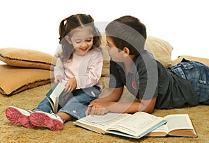 Brother and sister reading books on the floor