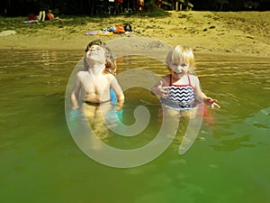 Brother and sister relaxing on chairs in a water