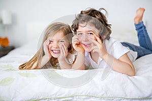 Brother And Sister Relaxing Together In Bed