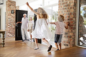 Brother and sister rush to meet their visiting grandparents