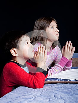 Brother and sister say prayers.