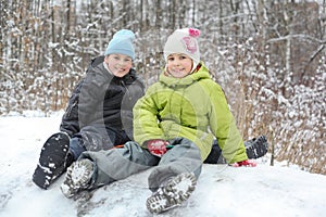 Brother, sister seat on saucer near trees