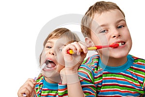 Brother and sister in shirts brush their teeth