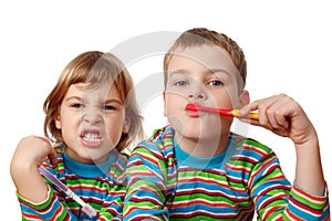 Brother and sister in shirts brush their teeth