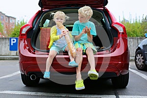 Brother and sister sitting in family car