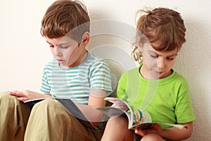 Brother and sister sitting and read books